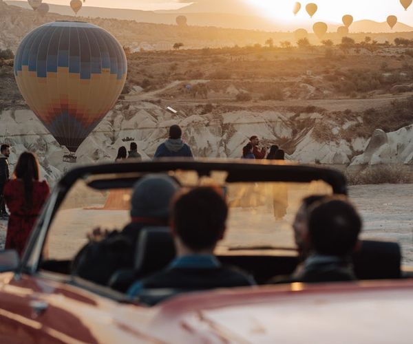 A person joyfully jumping in the air against a backdrop of a sunrise.